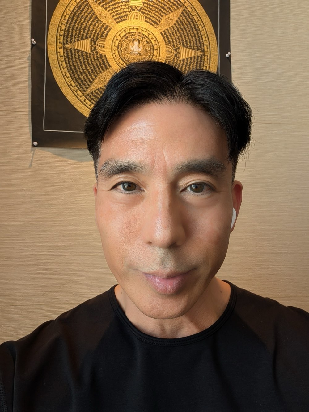 Alex Yamane in front of a golden thangka painting